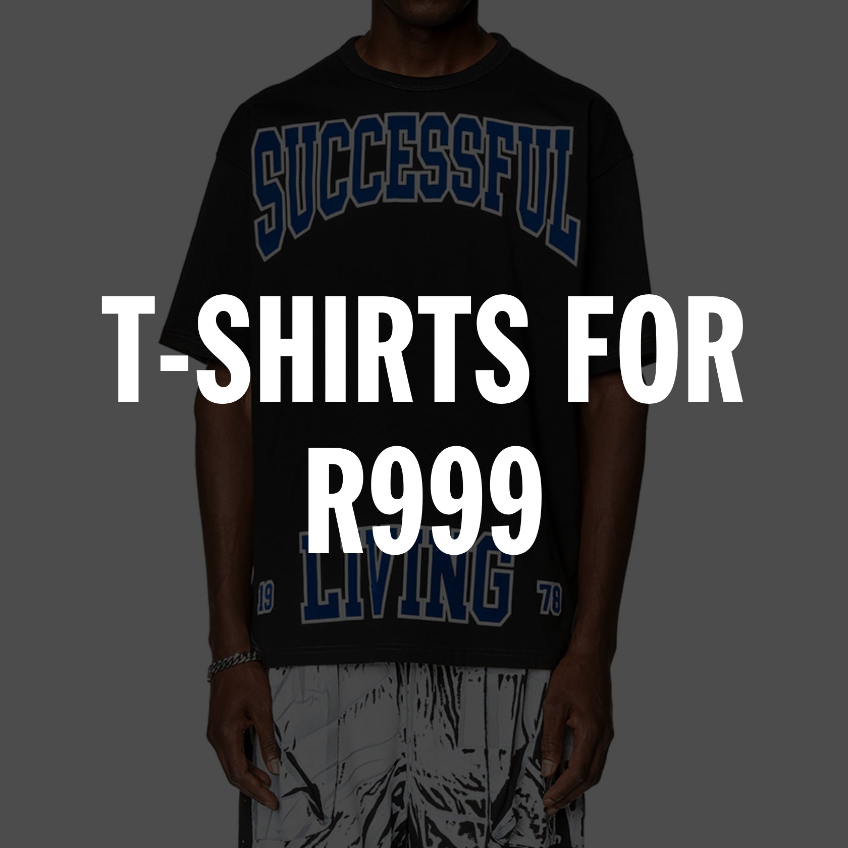 Man wearing a black graphic t-shirt with blue text and printed pants.