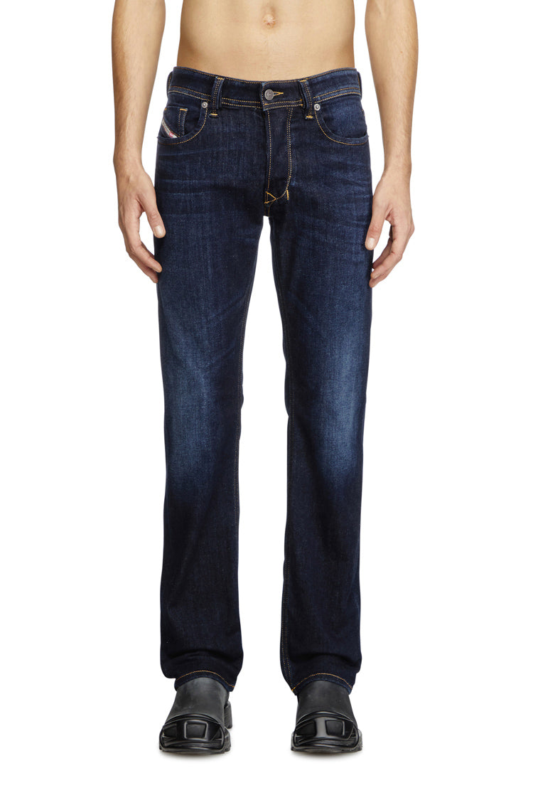 Person wearing dark blue jeans on a white background