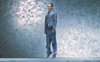Man wearing a blue casual jacket and blue denim jeans against a textured blue wall.
