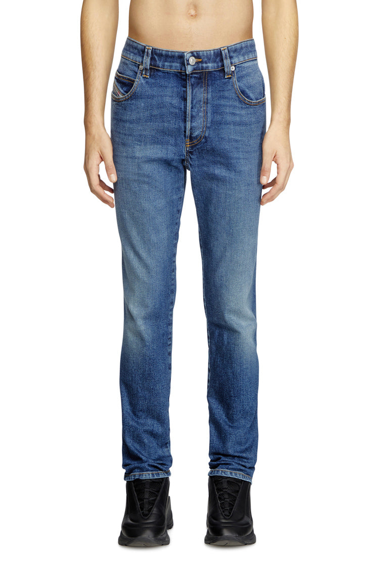 Blue jeans worn by a person on a white background
